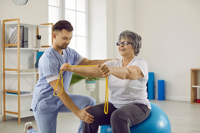 young-doctor-at-rehabilitation-centre-helps-senior-patient